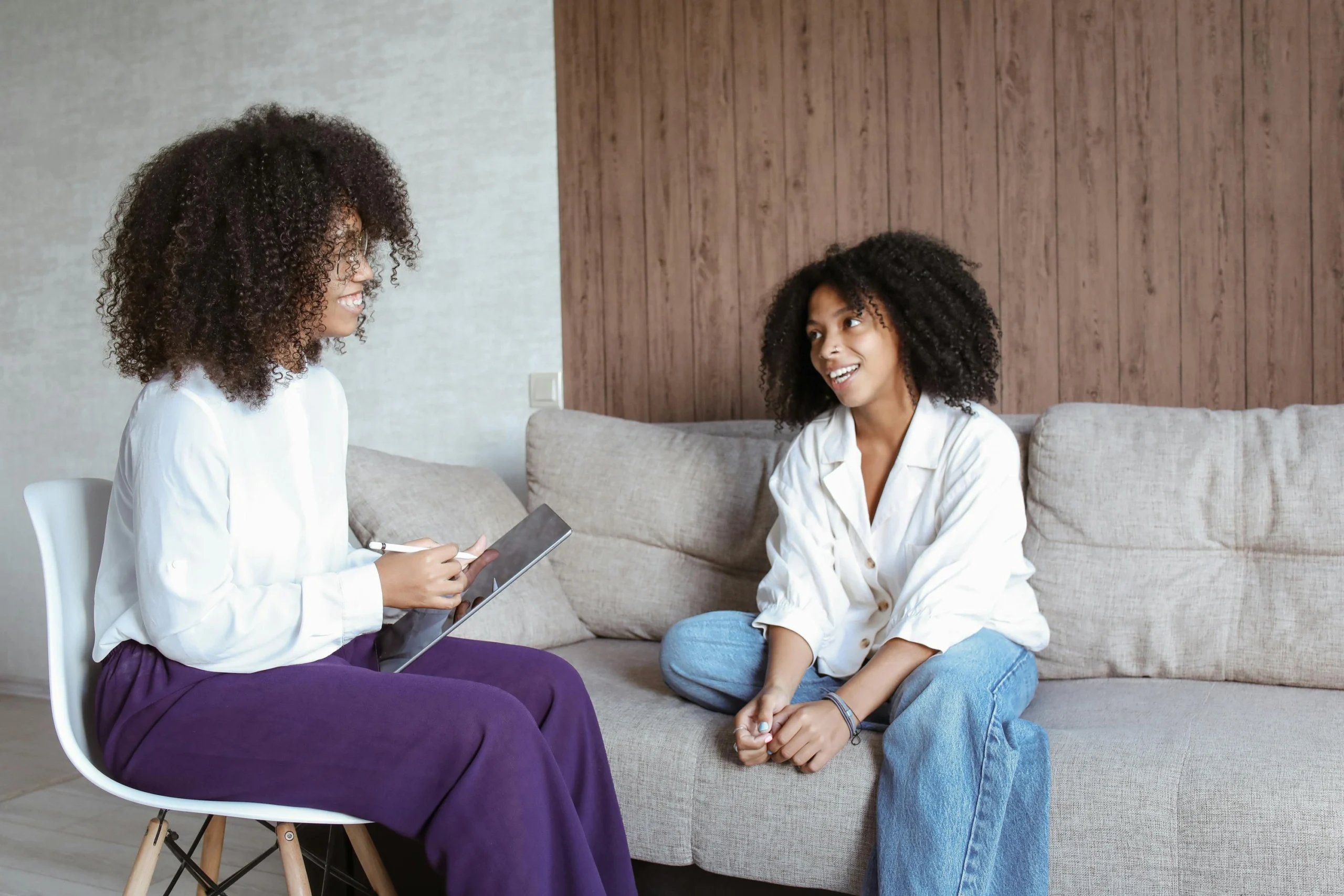 A teenage boy in a counseling session discussing with a therapist in an office setting.