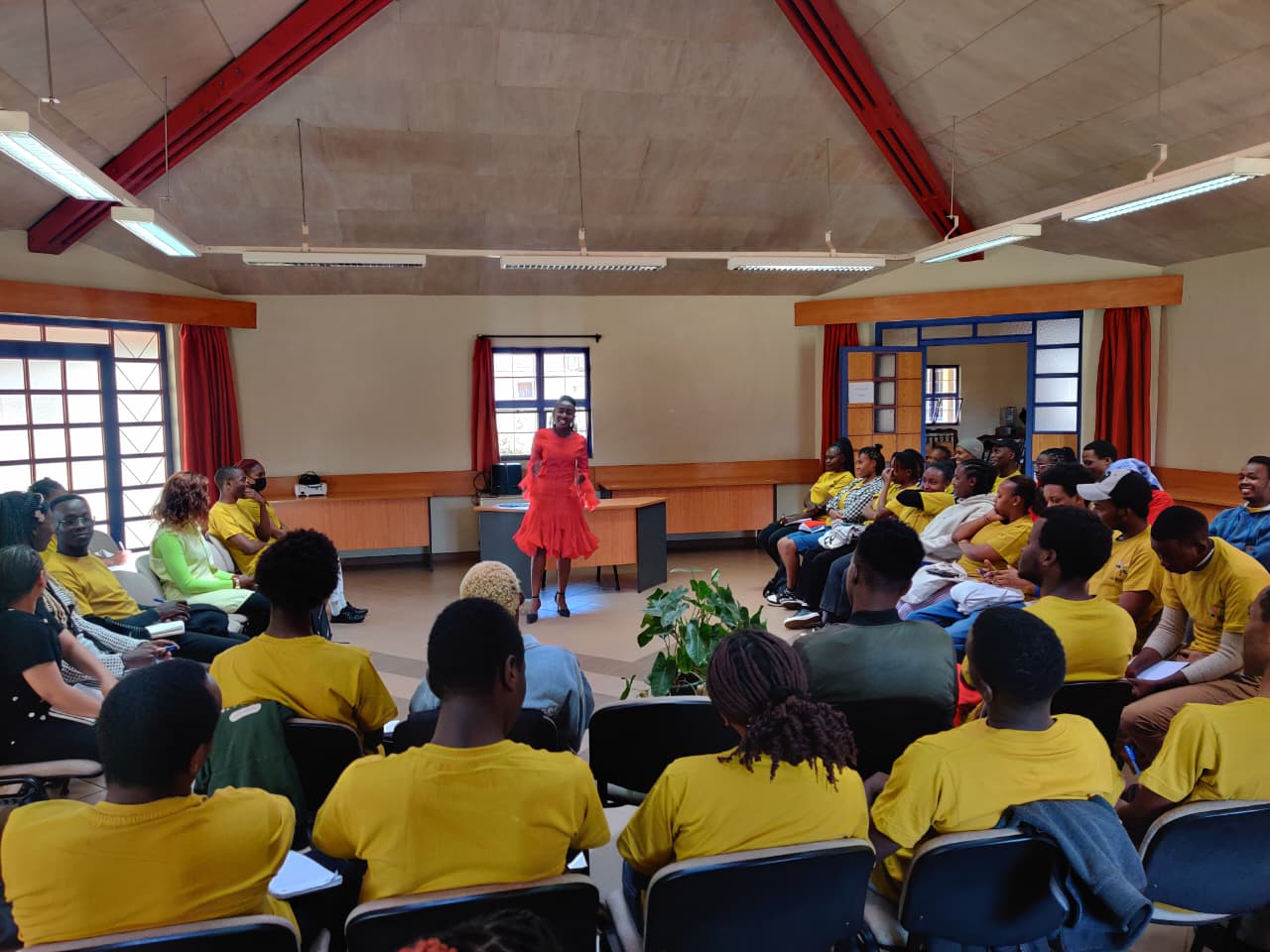 A caring teacher embraces a student in a library, fostering a warm and supportive learning environment.